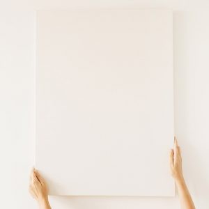 Blank canvas with empty mockup copy space in female hands. Minim Blank canvas